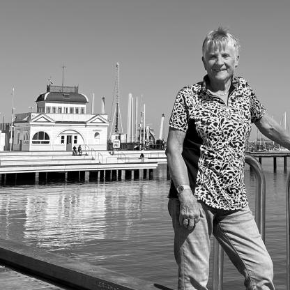man standing on a pier smiling to camera