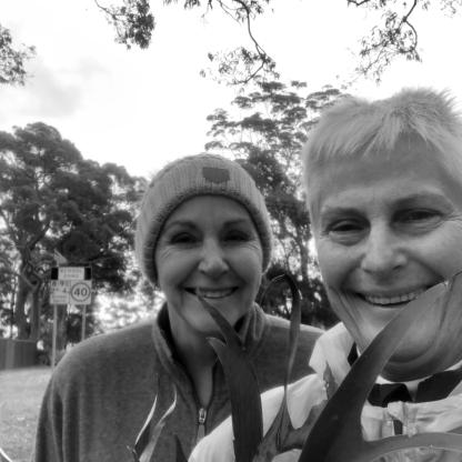 two women taking a selfie in the park, both smiling to camera