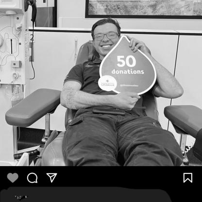 social media feed showing a man sitting in the donation chair holding a 50 donations sign