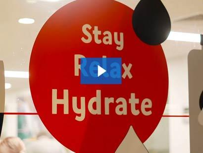 a red sign on a window with stay, hydrate, relax written in white text