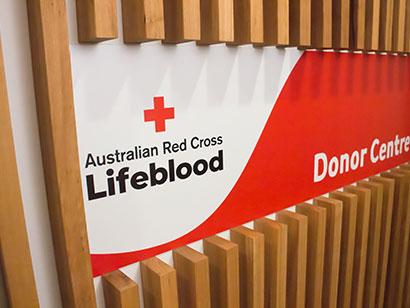 angle view of a sign on a wall with the Lifeblood logo on the left and donor centre is written on the right
