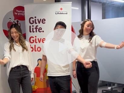 image of three donors with arms wrapped in bandages in front of a sign that says give life, give blood