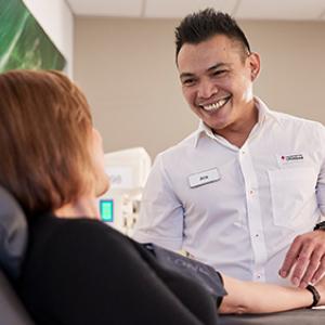 Male nurse tending to female blood donor