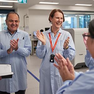 Group of Lifeblood laboratory workers clapping hands together