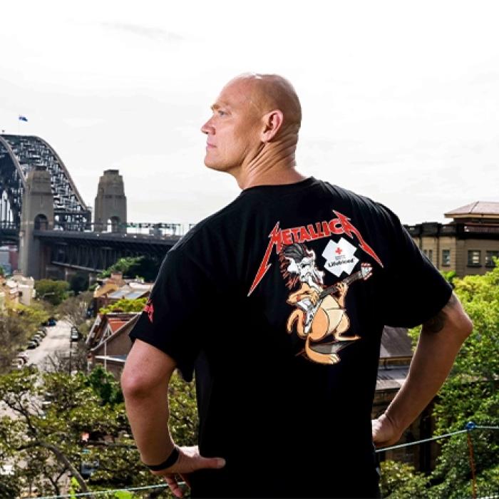 Michael Klim wearing the Lifeblood and Metallica collab t-shirt looking towards the Sydney harbour bridge