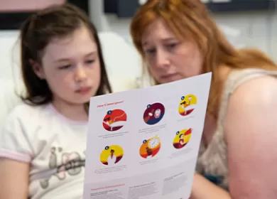 a child and parent are reading an information sheet