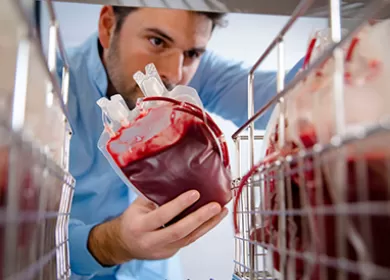 a scientist is placing a blood donation onto a storage shelf