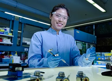 a scientist is in a laboratory wearing blue gloves and protective glasses while holding a test tube